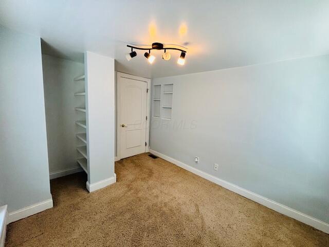 unfurnished bedroom with carpet floors and baseboards