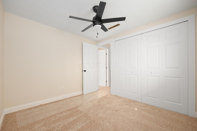unfurnished bedroom with a closet, baseboards, a ceiling fan, and carpet flooring