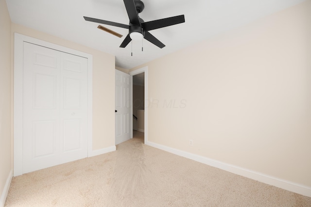 unfurnished bedroom with ceiling fan, visible vents, carpet floors, baseboards, and a closet