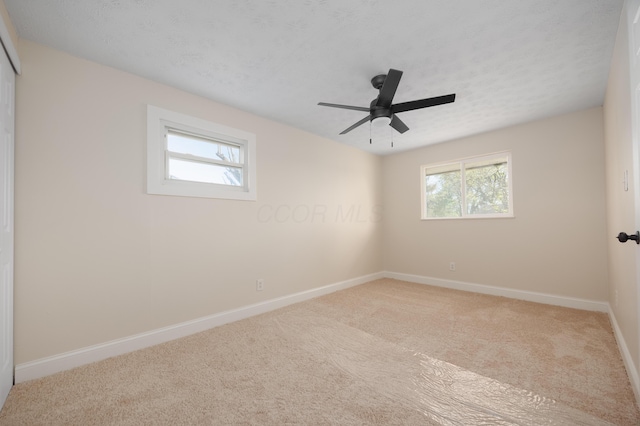 spare room with carpet floors, baseboards, and a ceiling fan