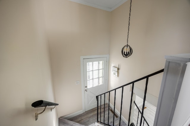 staircase with baseboards, ornamental molding, and wood finished floors