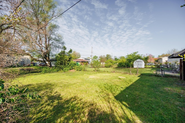 view of yard with an outdoor structure, fence, and a shed