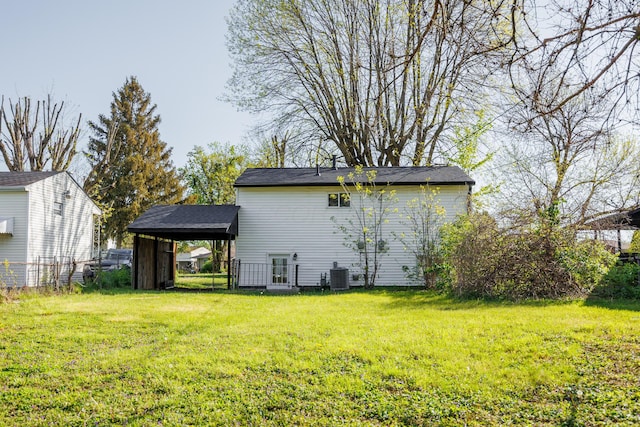 back of house with fence, a carport, a lawn, and cooling unit