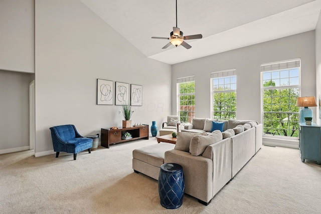 living room with ceiling fan, light carpet, baseboards, and high vaulted ceiling