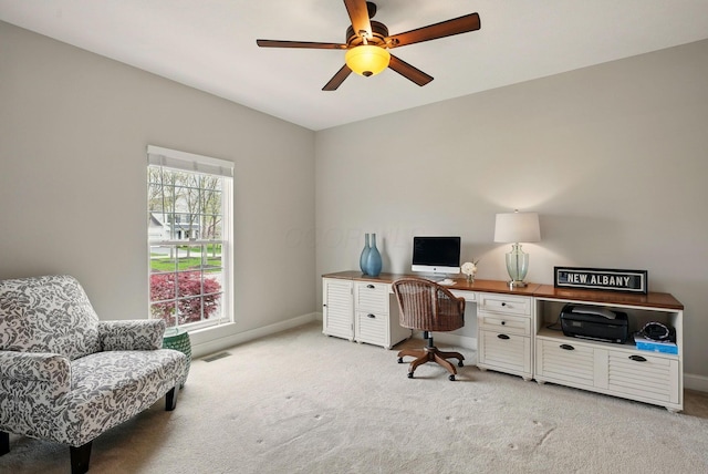 office with a ceiling fan, baseboards, visible vents, and light carpet