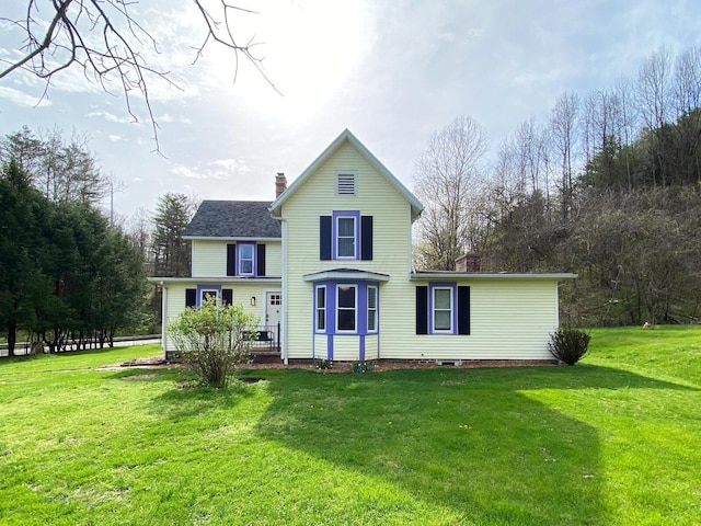 view of front facade featuring a chimney and a front yard