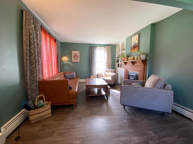 living area with wood finished floors, a baseboard heating unit, and a fireplace