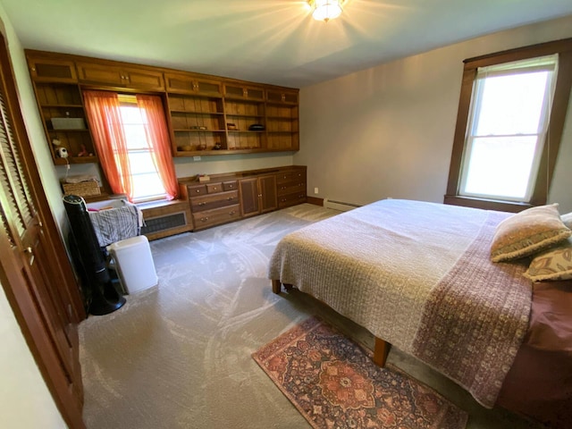 bedroom with baseboards, carpet, and a baseboard heating unit
