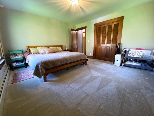 carpeted bedroom with a closet and a baseboard heating unit