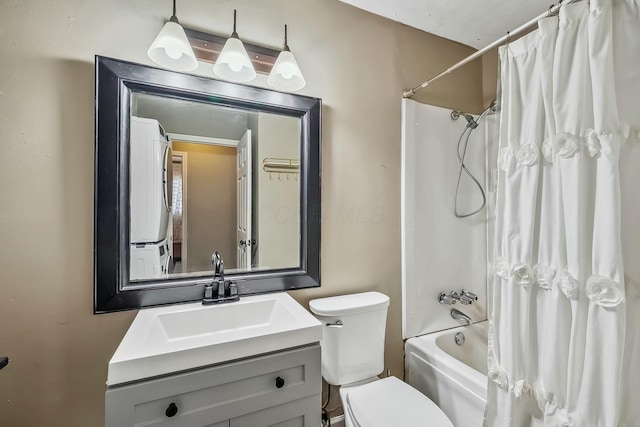 full bath featuring vanity, shower / bath combo with shower curtain, toilet, and stacked washer and dryer