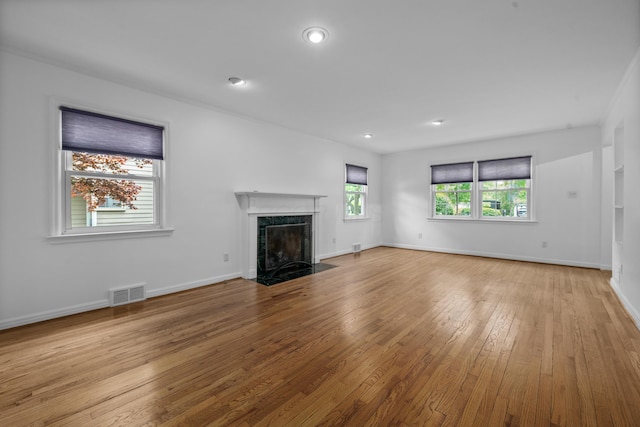 unfurnished living room with visible vents, a fireplace, baseboards, recessed lighting, and hardwood / wood-style flooring