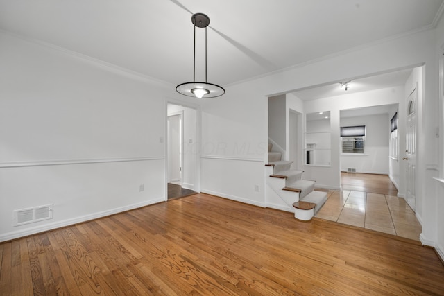 interior space featuring stairs, baseboards, visible vents, and ornamental molding