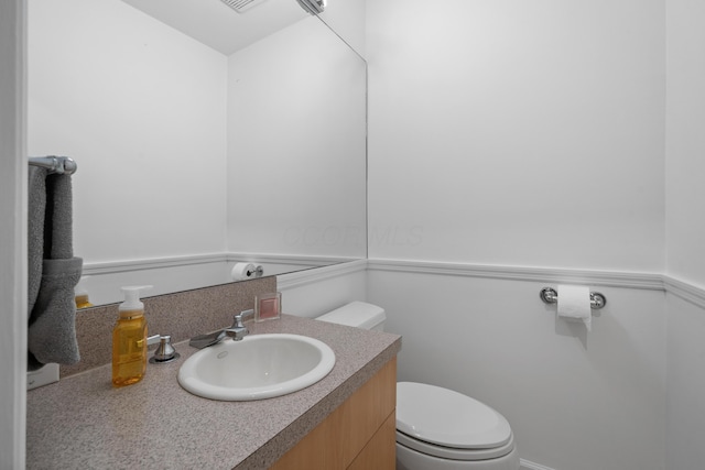 half bathroom featuring toilet and vanity