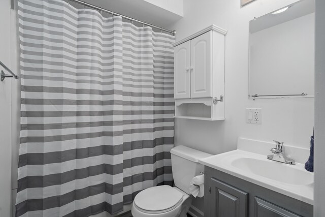 full bathroom with vanity, a shower with shower curtain, and toilet