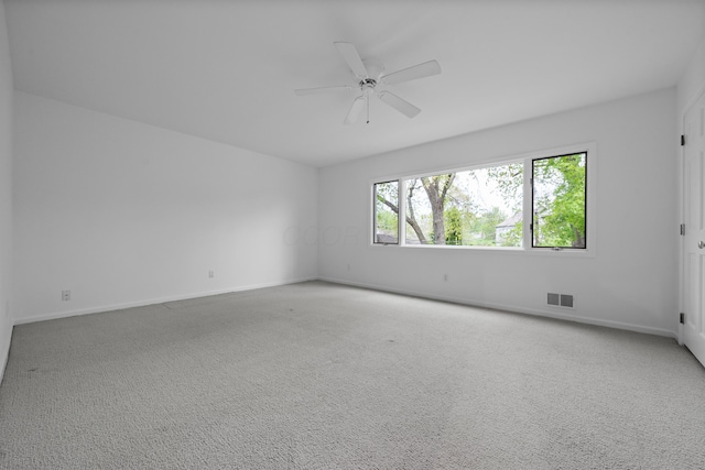 unfurnished room with a ceiling fan, baseboards, visible vents, and carpet