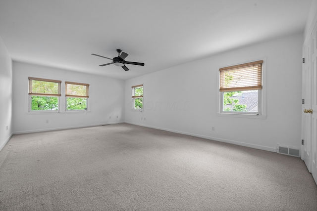 unfurnished room with visible vents, a ceiling fan, baseboards, and carpet floors