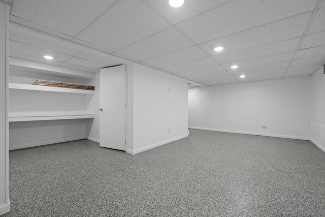 finished basement featuring baseboards, recessed lighting, and a paneled ceiling