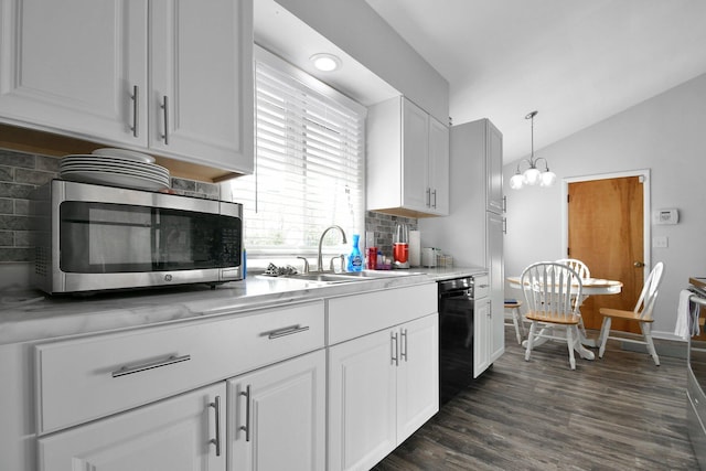 kitchen featuring lofted ceiling, black dishwasher, stainless steel microwave, a sink, and backsplash