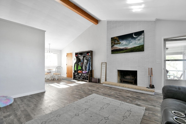 living room featuring an inviting chandelier, a fireplace, baseboards, vaulted ceiling with beams, and wood finished floors