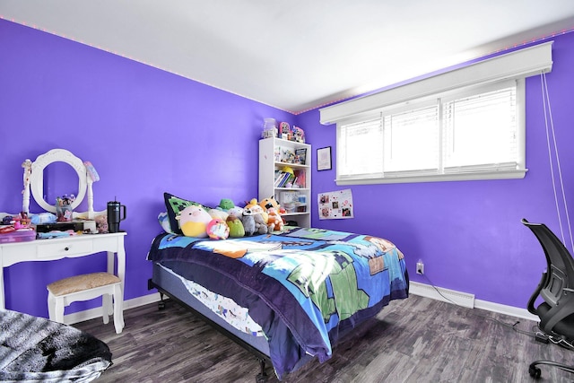bedroom with baseboards, baseboard heating, and wood finished floors