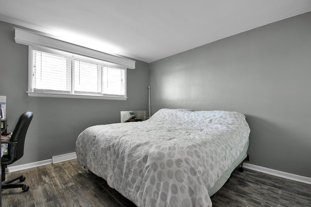bedroom with baseboards and dark wood-style flooring