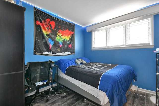 bedroom with baseboards and wood finished floors