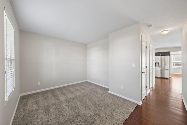 unfurnished room with baseboards