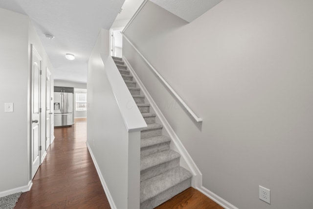 stairway with baseboards and wood finished floors