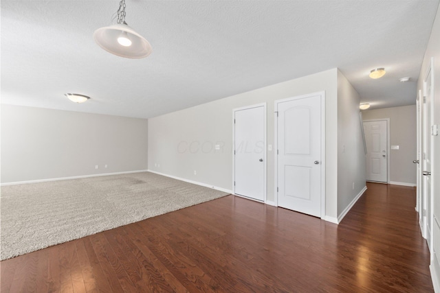 empty room featuring baseboards and dark wood-style floors