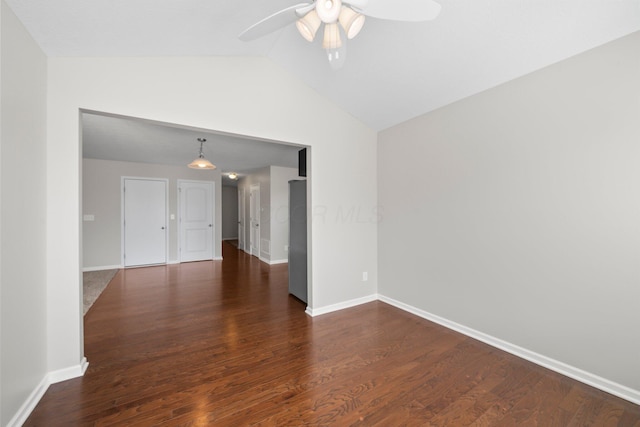 spare room with vaulted ceiling, baseboards, a ceiling fan, and wood finished floors