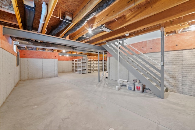 unfinished below grade area featuring stairs and brick wall