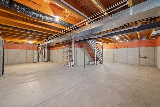 unfinished basement featuring water heater, heating unit, and stairway