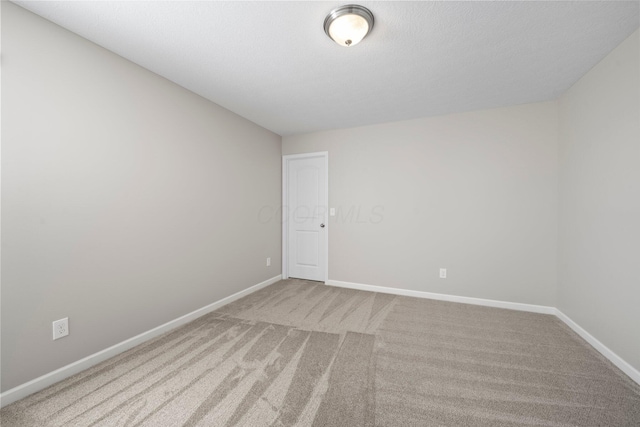 spare room with baseboards and carpet
