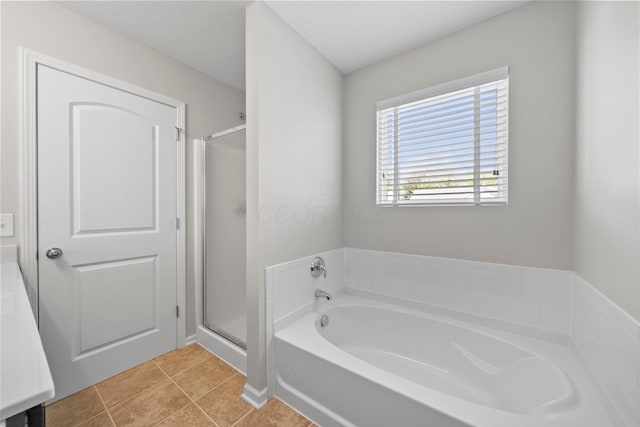 full bath with a garden tub, tile patterned floors, and a stall shower