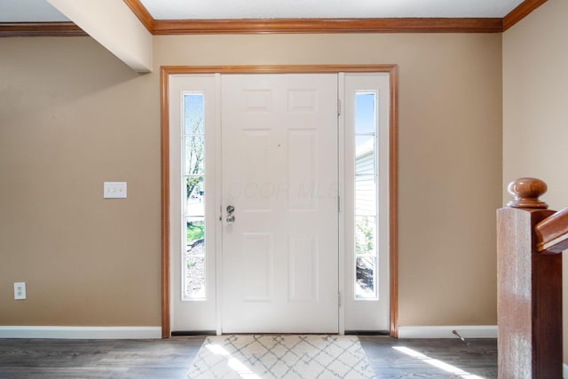 foyer featuring crown molding, baseboards, and wood finished floors