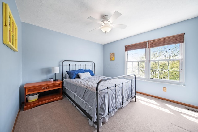 carpeted bedroom with visible vents, baseboards, and ceiling fan