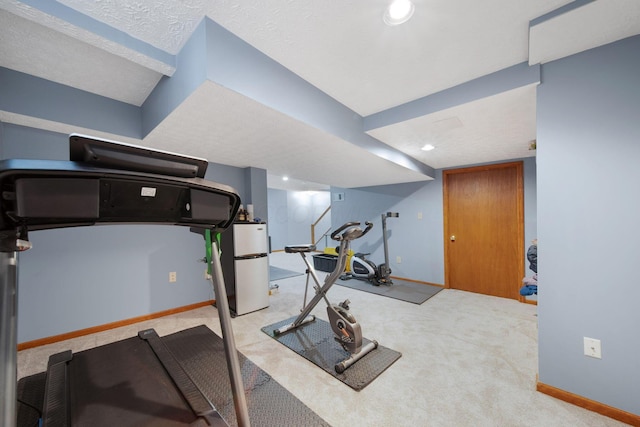 exercise area featuring baseboards, recessed lighting, and carpet