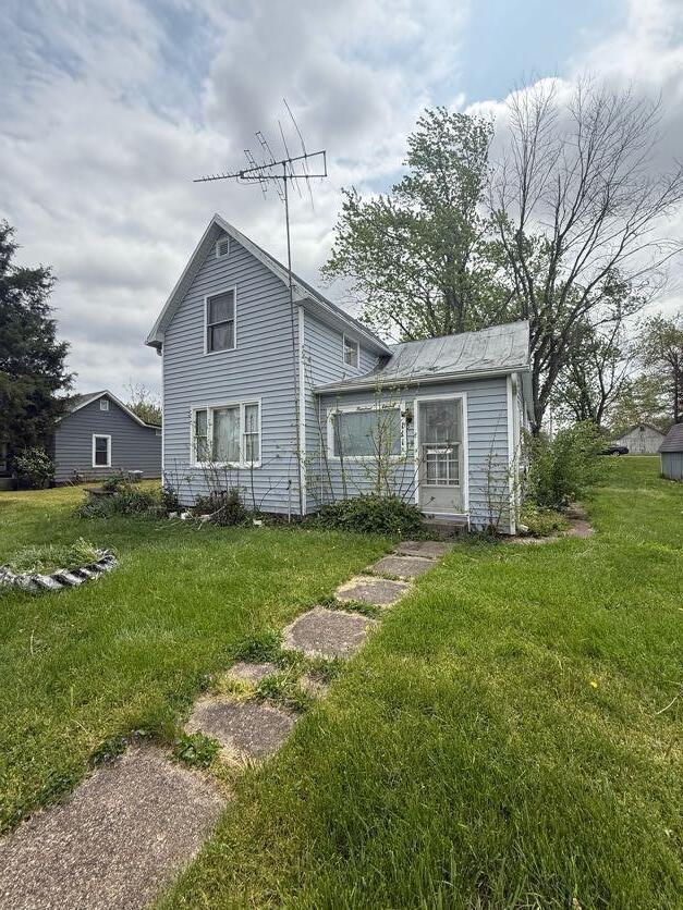 rear view of house featuring a yard