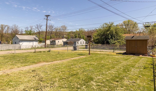 view of yard featuring an outbuilding, fence, and a storage shed