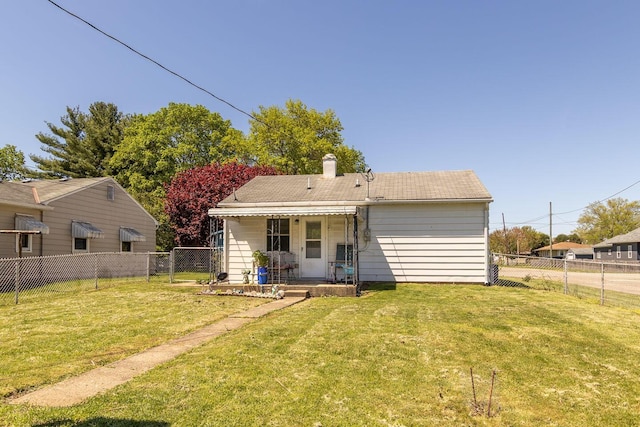 back of house with a yard, a chimney, a fenced backyard, and a porch