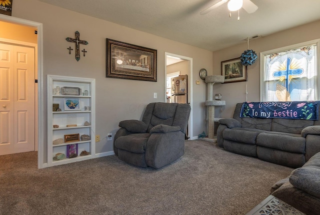 carpeted living area featuring a ceiling fan