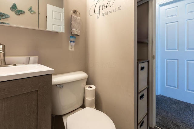 half bath featuring vanity and toilet