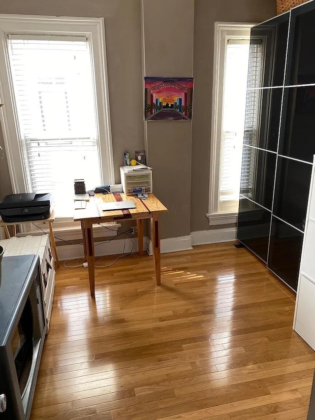 dining room with baseboards and light wood finished floors