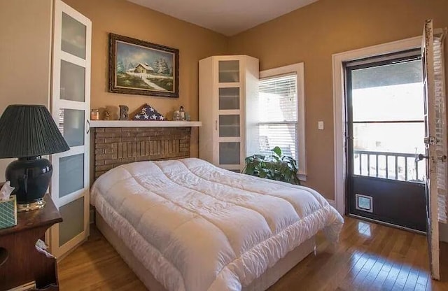 bedroom with access to outside and hardwood / wood-style flooring