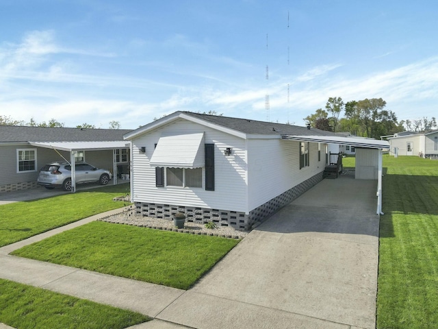 manufactured / mobile home with an attached carport, a front lawn, and driveway