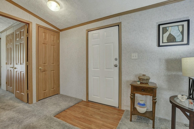 entrance foyer featuring vaulted ceiling, crown molding, and a textured ceiling