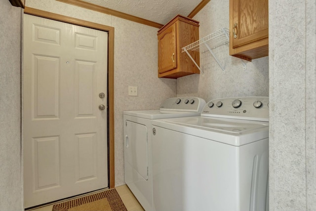 washroom with a textured ceiling, light tile patterned flooring, crown molding, separate washer and dryer, and cabinet space