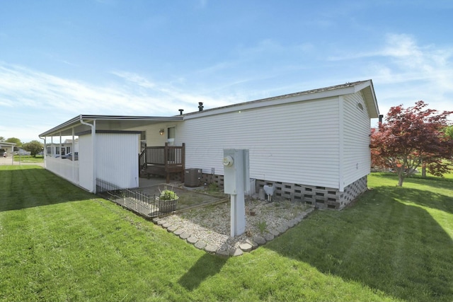 back of property with central AC unit and a lawn