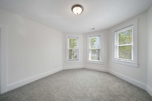 carpeted empty room featuring baseboards