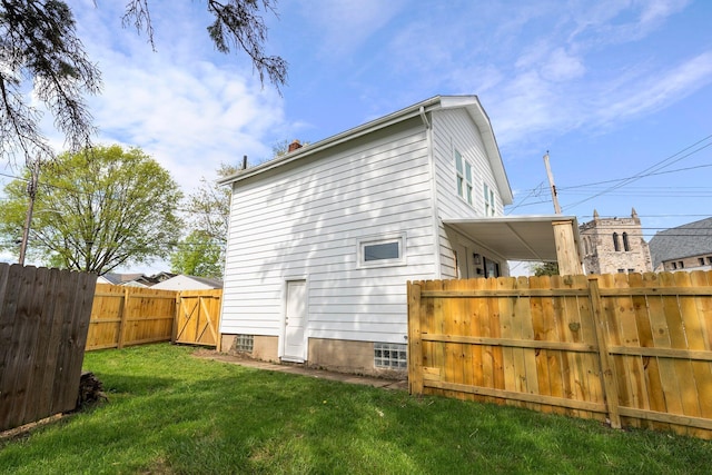 2671 Whitehead Rd, Columbus, OH 43204 - back of property featuring a chimney, a fenced backyard, a yard, and a gate